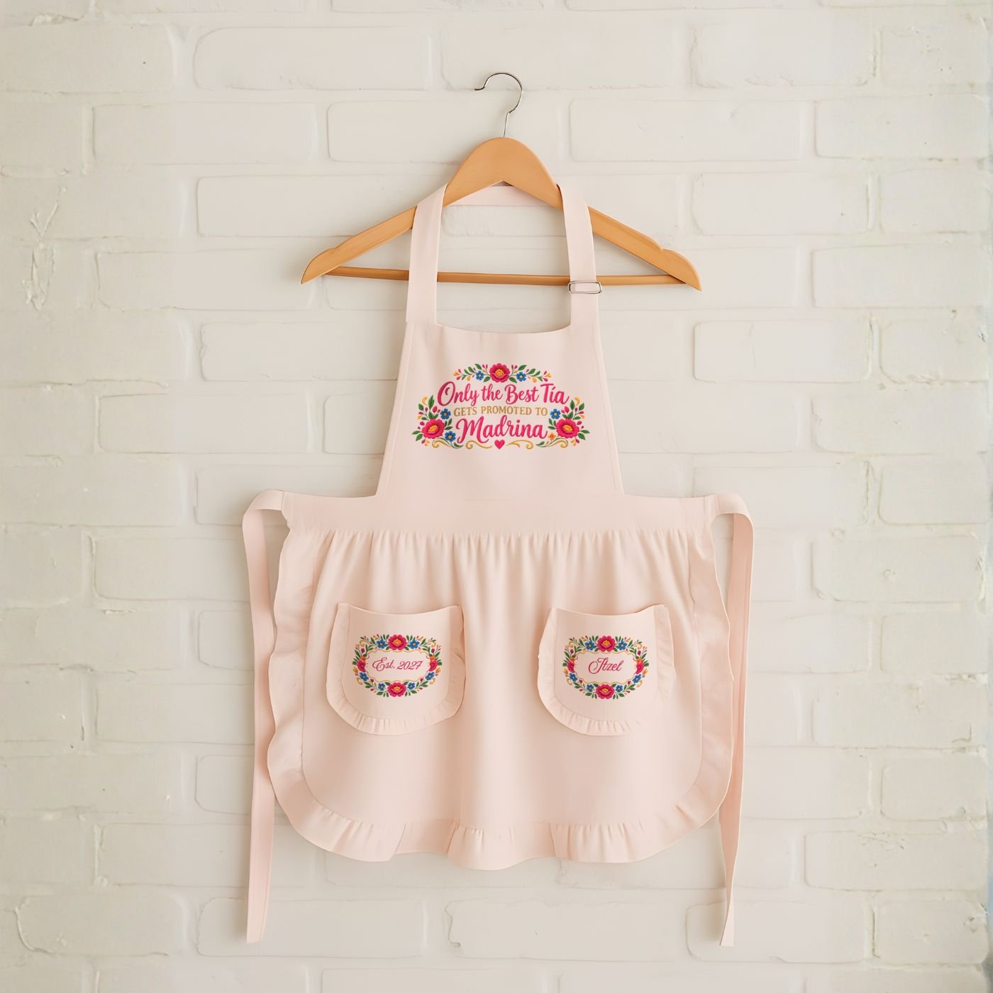 Only the best tia gets promoted to madrina pink apron flatlay